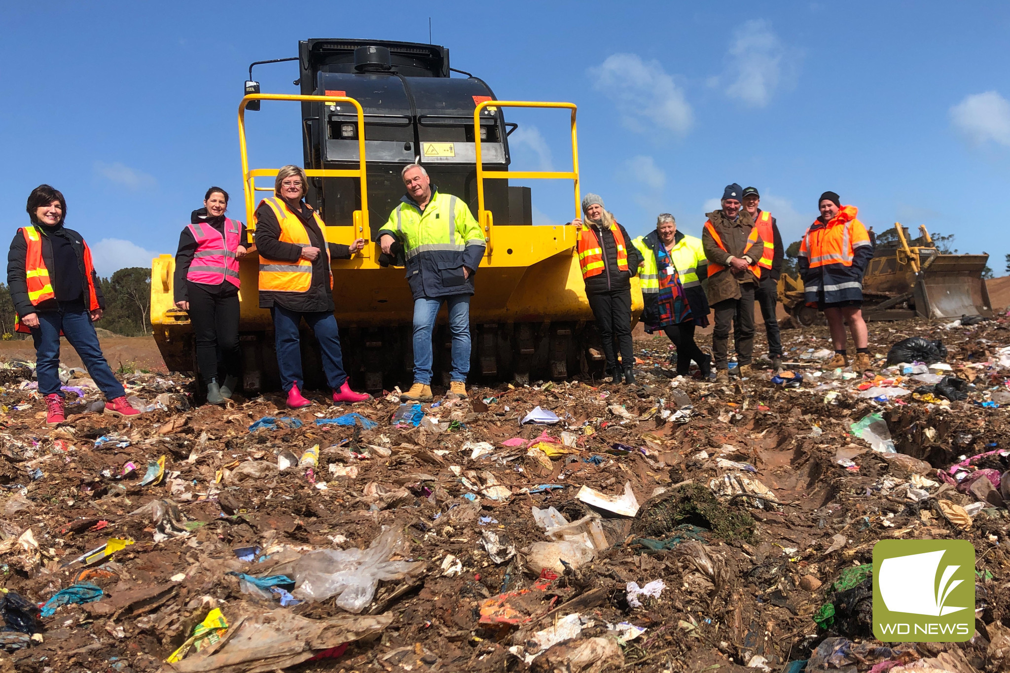 Making a difference: Corangamite Shire Cr Geraldine Conheady, mayor Kate Makin, Cr Ruth Gstrein, deputy mayor Laurie Hickey, Cr Jo Beard, director sustainable development Justine Linley, Cr Nick Cole, Cr Jamie Vogels and plant operator Tom McDonald with the new compactor at Corangamite Regional Landfill.