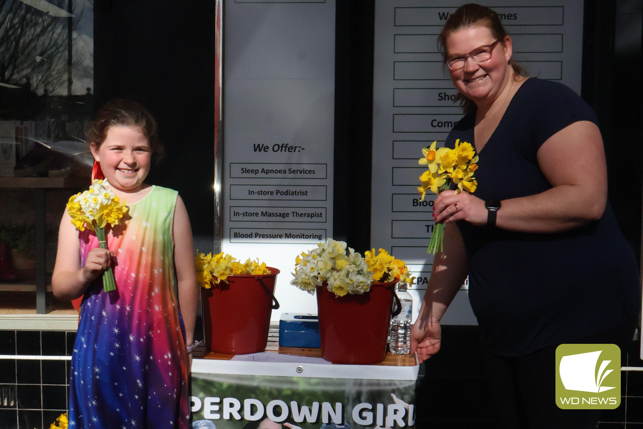 Touch of colour: Maddilyn Kampjes (left) and Liz Sutherland manned the stall over the weekend as the Camperdown Girl Guides held their annual daffodil sale fundraiser.