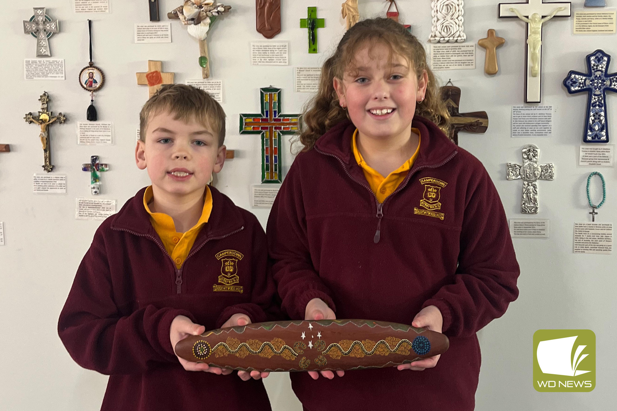 A travelling stick: Aaron Marshall and Lilah Alexander hold the Diocese of Ballarat message stick, one of four making their way around Catholic schools within the area.